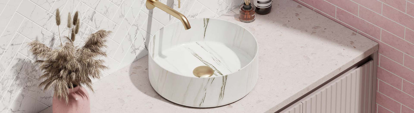 Round natural marble bathroom basin with gold tap on stone vanity