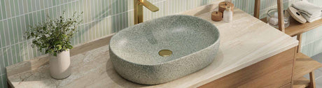 Elegant porcelain basin with a matte stone finish and gold tapware on a marble vanity top