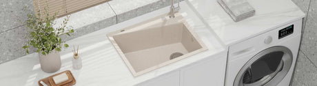Beige granite laundry sink with matching tap on a white benchtop