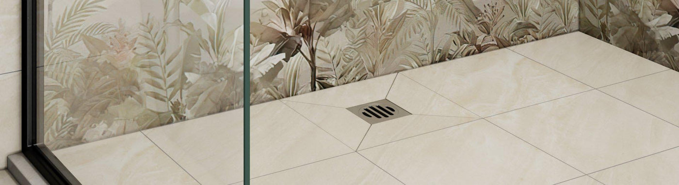 Close-up of a tiled shower floor with a centred square grate and fall lines leading to the drain.