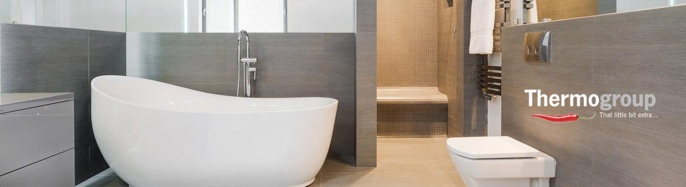 ThermoGroup heated towel rails in a white tiled bathroom.