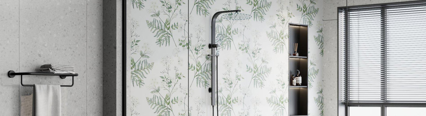 Black curved overhead arm with round rain head paired with a separate slide rail and handset on a fern backdrop.