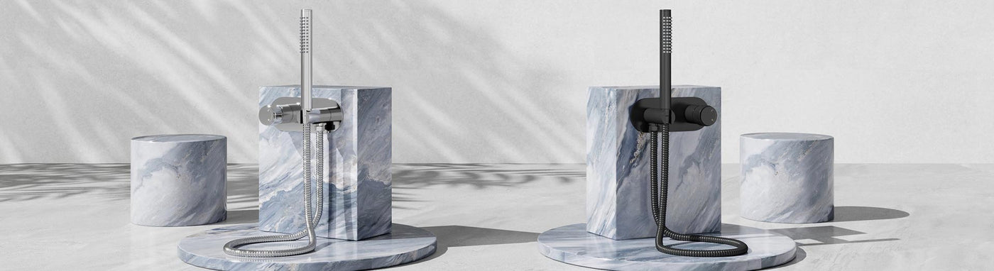 Wall mixer with hand shower sets in chrome and matte black on marble plinths.