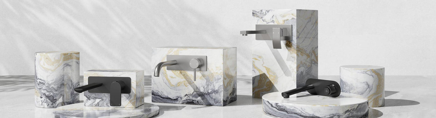 Wall mixer and spout sets in matte black and brushed nickel on marble plinths.