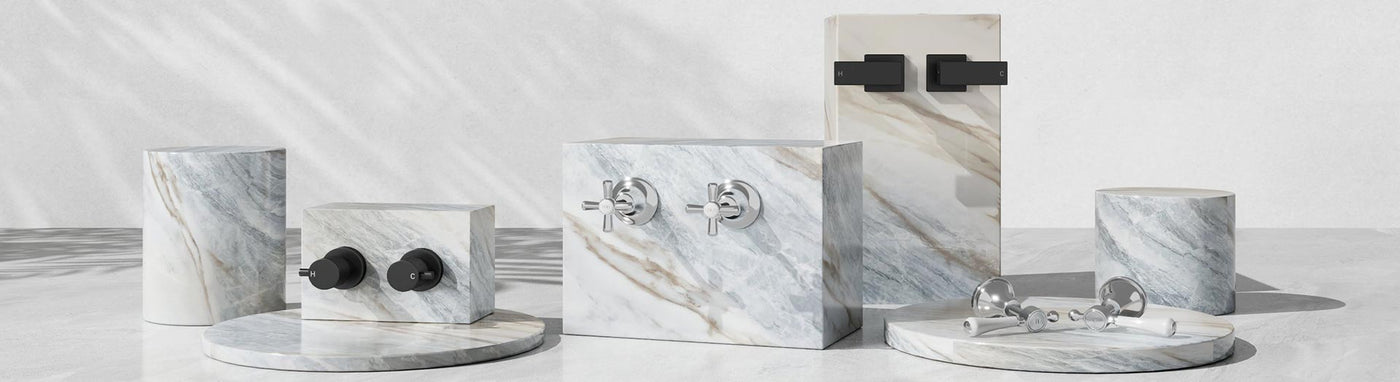 Wall top assemblies in chrome and matte black—round, cross and square handles on marble plinths.