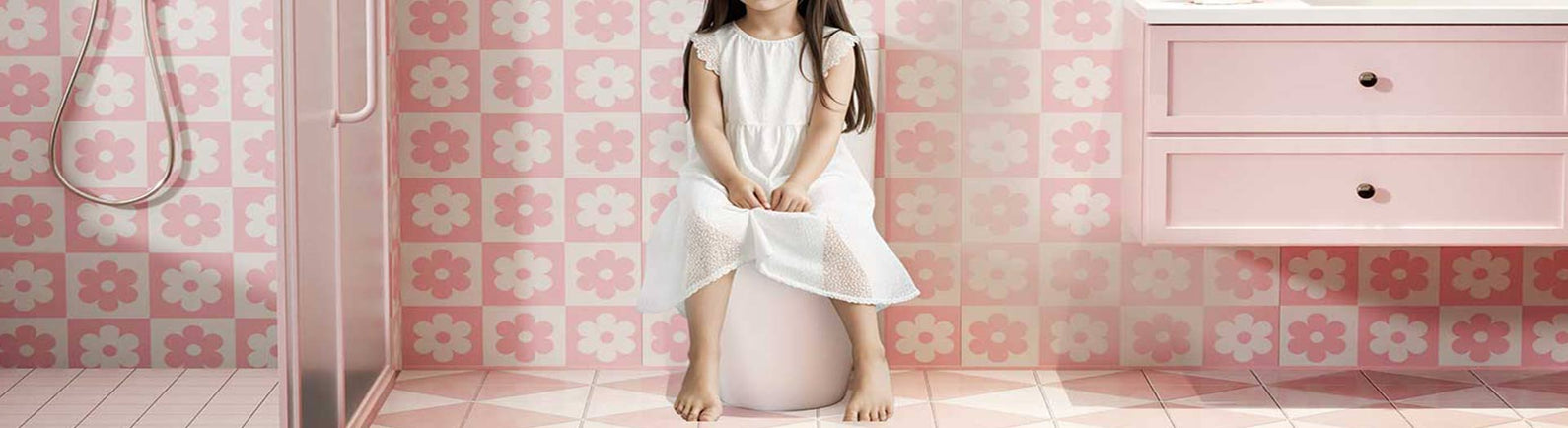 Pink child-friendly bathroom with junior toilet and floral tiles