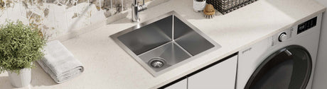 Single bowl stainless steel laundry sink with square edges in a contemporary laundry.