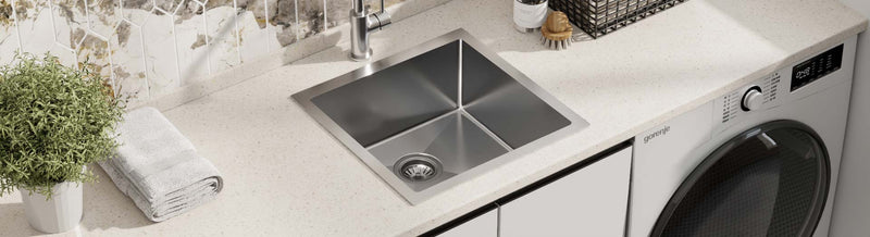 Single bowl stainless steel laundry sink with square edges in a contemporary laundry.
