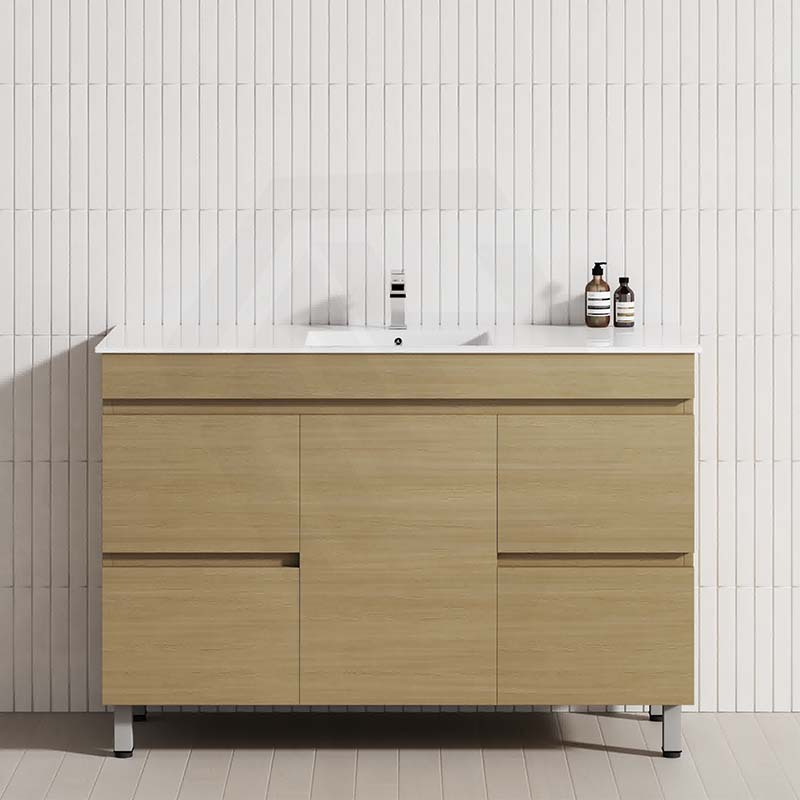 Freestanding 1200mm bathroom vanity in Tuross Oak, set against a white tiled wall, with a door and 4 drawers